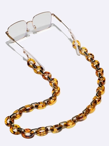Détail d'une chaîne de lunettes en acrylique écaille de tortue et maillons dorés