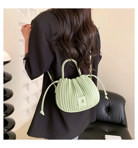 Detail of mint green pleated cloud bucket bag with drawstring and leather shoulder strap