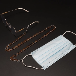 Close-up of leopard acrylic eyewear chain showing amber links and anti-slip hooks