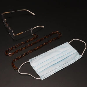 Detail of amber acrylic glasses chain with anti-slip rubber loops and metal lobster clasps