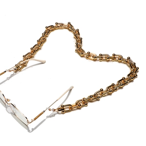 Chaîne à lunettes dorée à maillons en U et perles métalliques disposée en forme de cœur