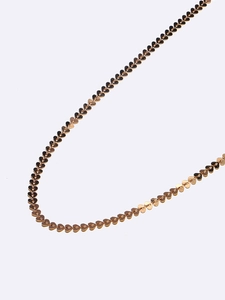 Macro shot of gold handmade heart-shaped links on this delicate eyewear and mask chain