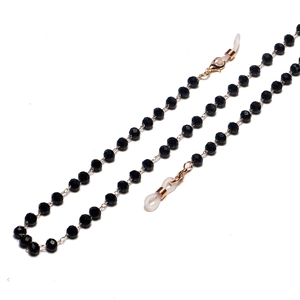 Close-up of black faceted crystal beads on eyewear chain with gold lobster clasps