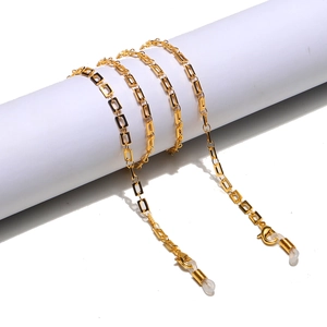 Macro detail of golden rectangular link chain for eyewear featuring lobster clasps