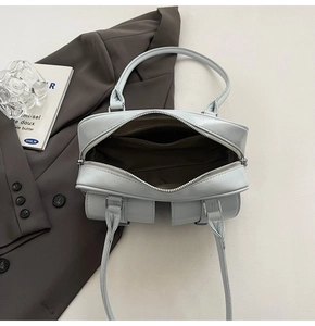 Top view showing the spacious dark fabric interior and zipper of the chic light blue bag