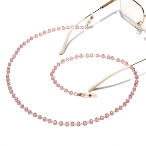 Close-up of pink crystal beads on a non-slip eyewear chain with golden metal parts