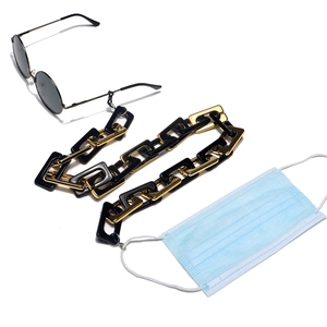 Detail of chunky black and gold link chain used as eyewear and face mask lanyard