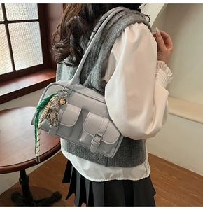 Fashionable light blue patent leather shoulder bag with multi-pockets shown on a model