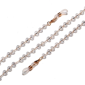 Close-up of clear faceted crystal beads and gold lobster clasps for eyewear chains