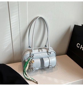 Detail of light blue-grey leather underarm bag with double front pockets and metal buckle