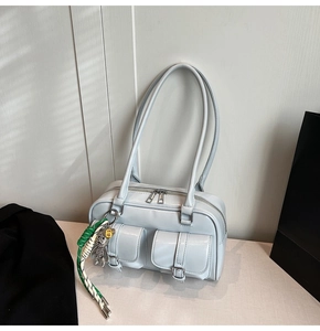 Close-up of light blue multi-pocket shoulder bag with metallic bunny charm detail