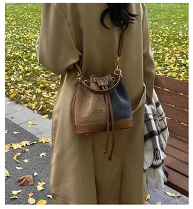 Detail of vintage patchwork bucket bag with drawstring closure on autumn grass background