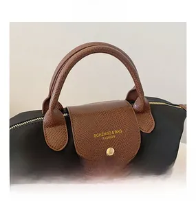 Detail of high-density nylon handbag with snakeskin embossed leather handle and gold hardware