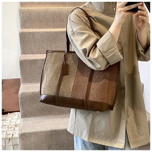Détail d'un sac cabas patchwork multicolore avec anses en cuir sur un fond intérieur doux