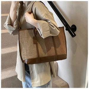 Détail du grand sac cabas en toile avec garniture en cuir marron et coutures sur mannequin