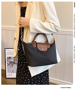 Detail of waterproof nylon tote with brown lychee leather handles and gold metal buckle