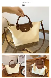 Detailed view of beige nylon dumpling bag with brown lizard-texture leather handles
