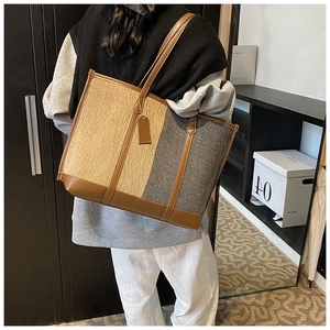 Vue détaillée des surpiqûres contrastées et de la texture tissée d'un grand sac cabas