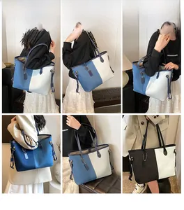 Detail of color-block denim tote bag with leather straps and metal side buckles