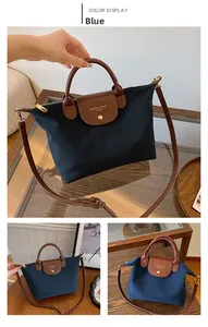 Blue nylon tote bag with brown faux leather handles and adjustable long shoulder strap