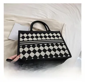 Detail showing black and white checkered woven canvas tote with luxury texture