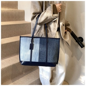 Détail d'un grand sac fourre-tout patchwork en tissu jacquard bleu et matière texturée