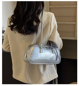 Silver wrinkled leather tote bag with bow detail shown on a model shoulder