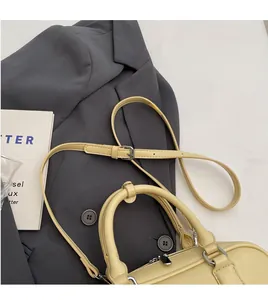 Detail of yellow lychee textured Boston bag featuring adjustable strap and silver metal zipper
