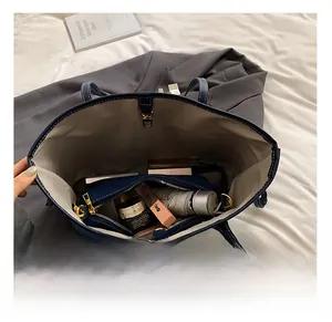 Interior view of navy blue tote bag showing large capacity for cosmetics and umbrella