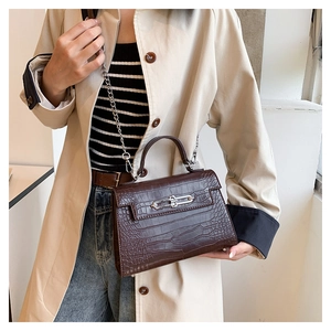 Close-up of brown crocodile texture leather bag featuring silver metal lock and chain strap