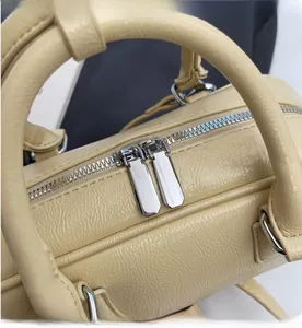 Detailed macro view of the silver metal two-way zipper and textured beige leather surface
