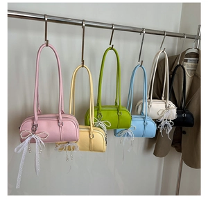 Detail view of colorful Boston shoulder bags with pearl charms and lace bows