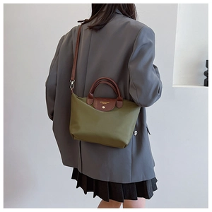 Detail of dark green nylon tote with leather handle and golden snap closure button