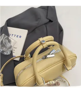 Detail of lychee pattern leather Boston bag in pale yellow with durable top handles