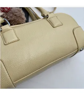 Detail of beige boston bag showing natural leather texture and soft material finish