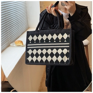 Detail of classic black and white diamond lattice pattern on a large canvas tote bag