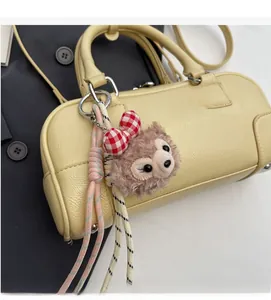 Detail of pale yellow Boston bag with soft texture and plush character charm