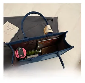 Top view of spacious denim tote interior holding a tablet, phone, and daily essentials
