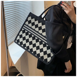 Detail of checkered canvas tote bag with central stripe showing fabric texture and shape