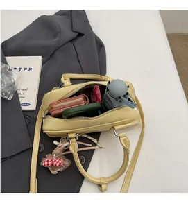 Spacious interior of light yellow Boston handbag showing phone, wallet and folding umbrella