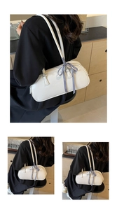 Close-up of white faux leather shoulder bag with a blue and white checkered bow detail