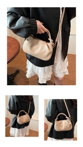 Detail of beige pleated bucket bag showing rounded handle and fashion text logo