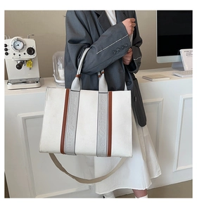 Détail du sac fourre-tout en toile avec finitions cuir marron et doubles bandoulières