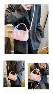 Detail of light pink pleated bucket bag with Fashion & Bags embossed logo and PU leather texture