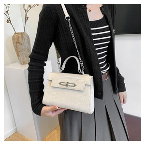 White crocodile embossed Kelly style handbag on model, chic fashion accessory detail
