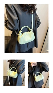 Detail of mint green pleated cloud bag with knotted handle and embossed fashion text