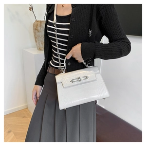 Detail of white crocodile pattern Kelly bag with silver metal clasp and chain strap