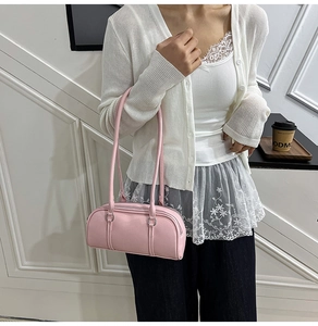 Detail of light pink lychee texture shoulder bag styled with a casual outfit