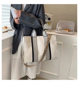 Détail du sac cabas en toile avec rayures contrastées et bandoulière à motif géométrique