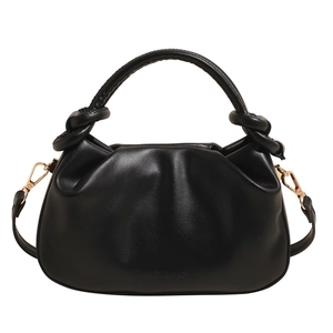 Minimalist black pleated bucket bag with knotted handle and adjustable shoulder strap
